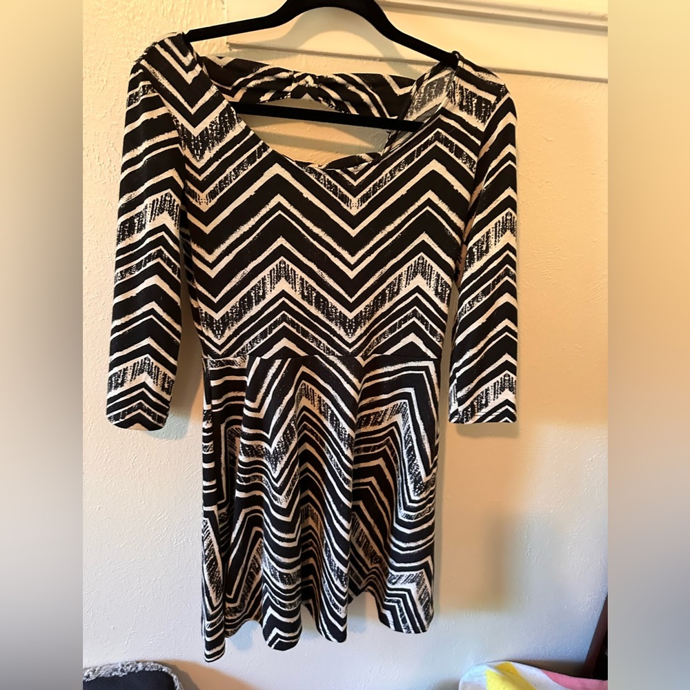 Black and white striped mini dress with sleeves and cutouts in back.